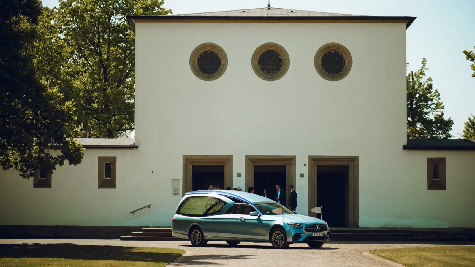 Bestattungswagen der Trauerhilfe Göck vor einer Trauerhalle